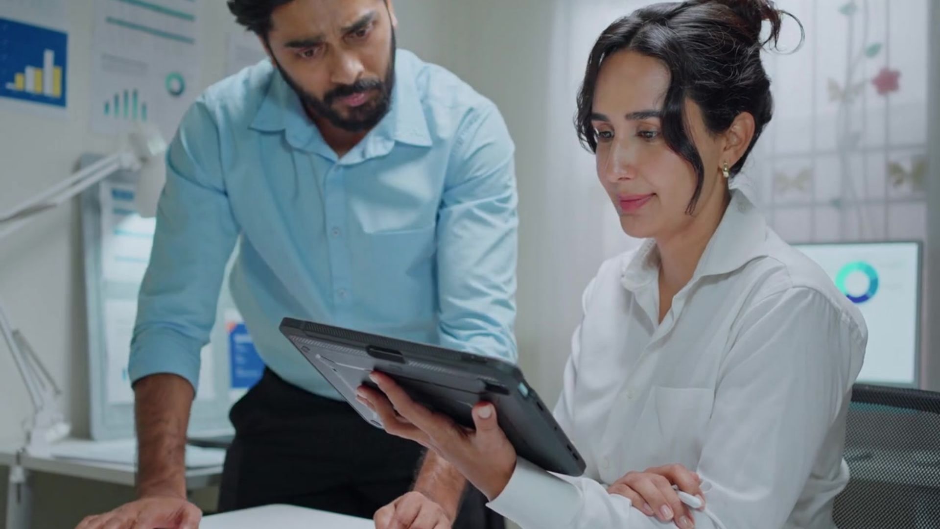 Two professionals reviewing information together on a laptop.